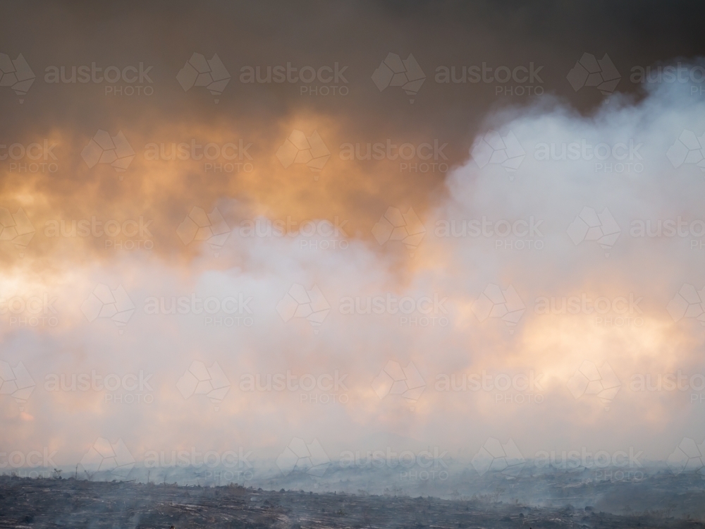 Burned off grasslands with billowing smoke - Australian Stock Image