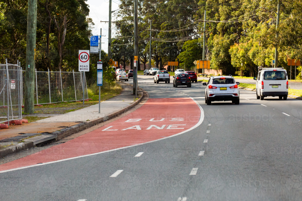 Bus Lane marking on road with sign and traffic passing - Australian Stock Image