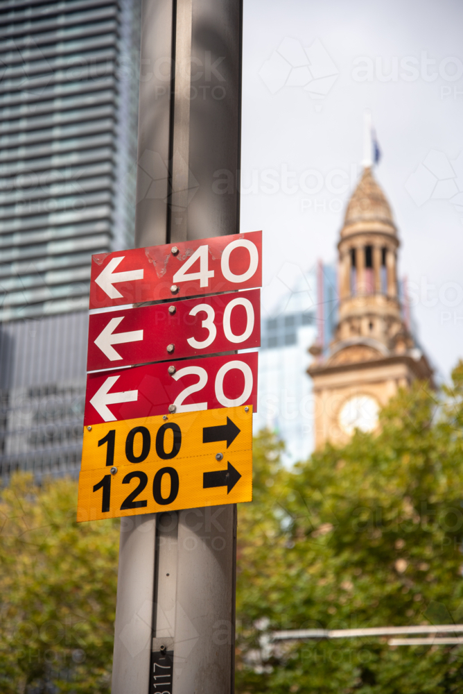 Bus routes sign with Town Hall clock tower out of focus in the background - Australian Stock Image