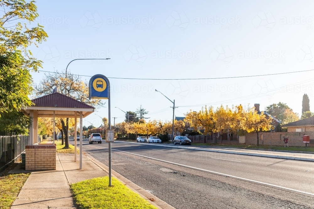 Bus stop sign and shelter on street of rural country town - public transport - Australian Stock Image
