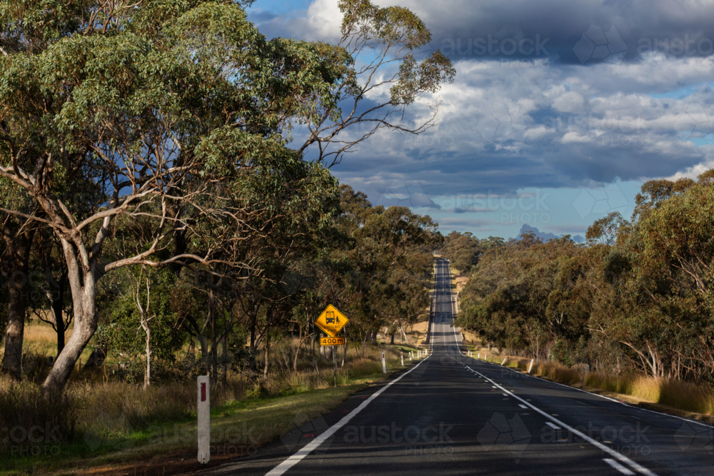 Image of Bus stop sign down rural highway in Australia - Austockphoto