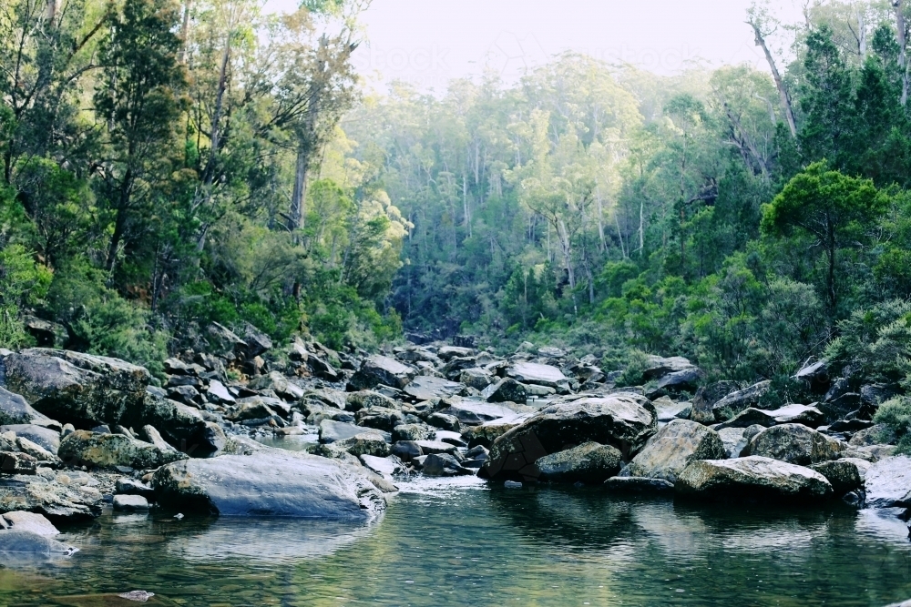 Bushland and rocks with a river in the foreground - Australian Stock Image