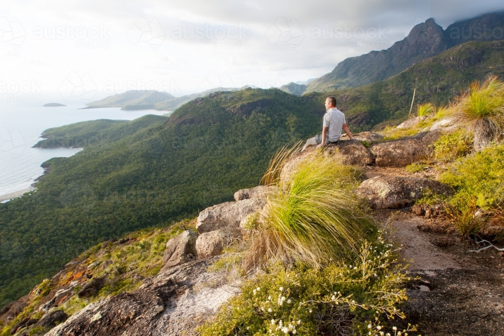 Bushwalker looking at view over coastline - Australian Stock Image