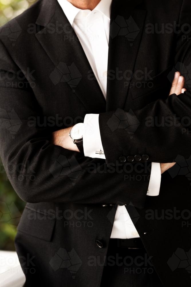 Business man in suit with arms folded - Australian Stock Image