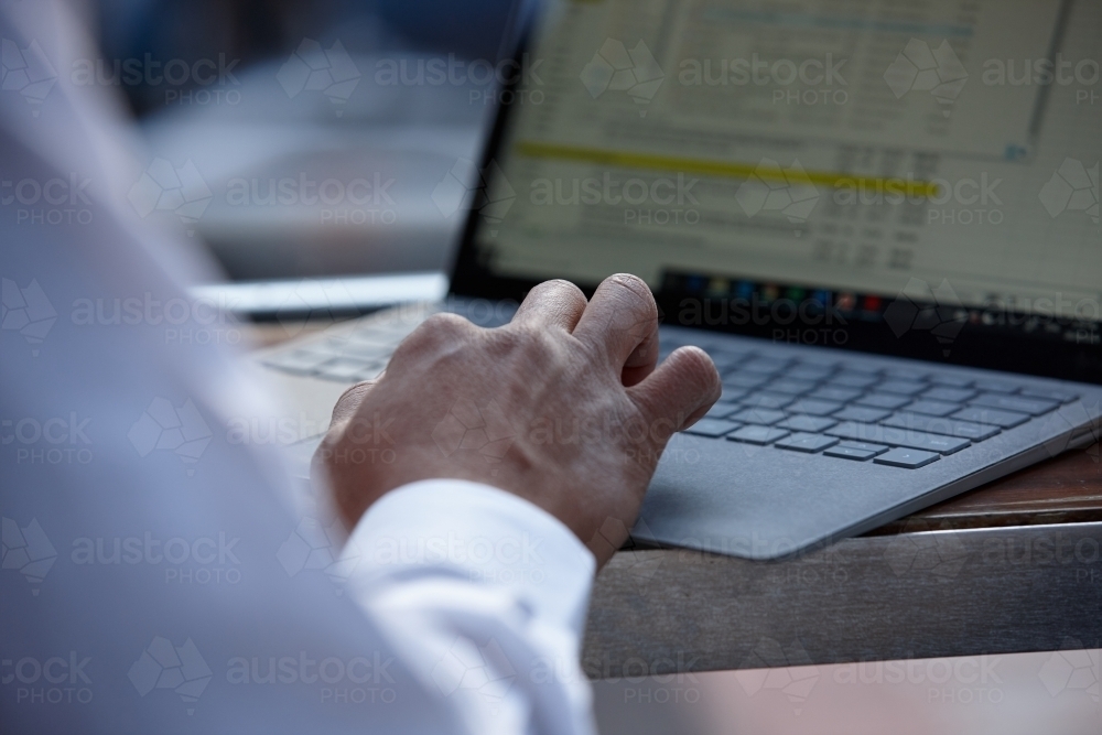 Business man using laptop keyboard at desk - Australian Stock Image