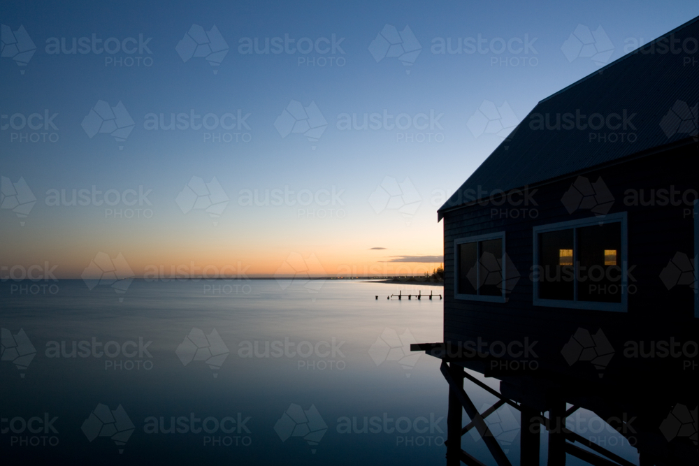 Busselton Jetty shimmers in the early morning in light in Busselton, Western Australia, Australia - Australian Stock Image