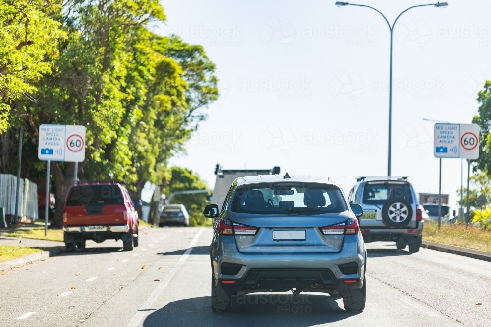 Image of Busy street in city with cars approaching speed camera sign ...
