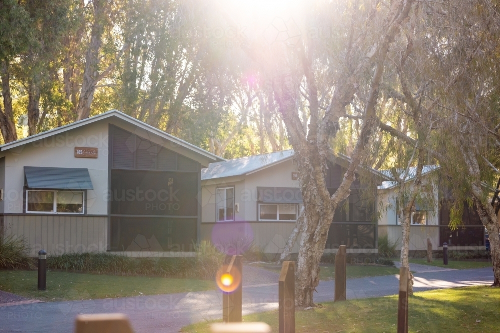Cabins in a caravan park in golden afternoon light - Australian Stock Image