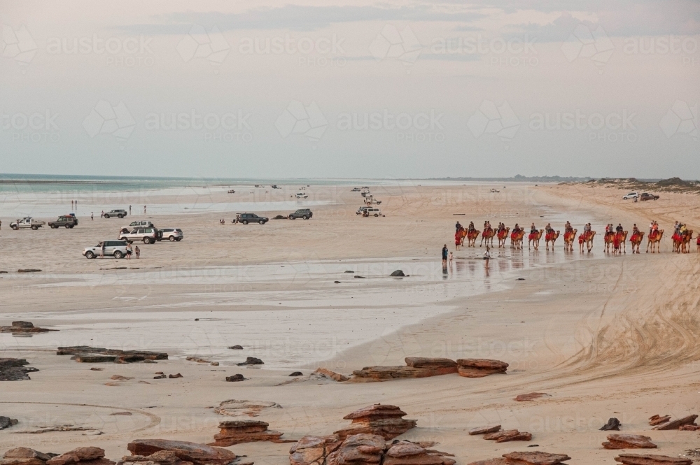 Cable beach Broome with camel rides and 4WD vehicles on the beach for sunset - Australian Stock Image