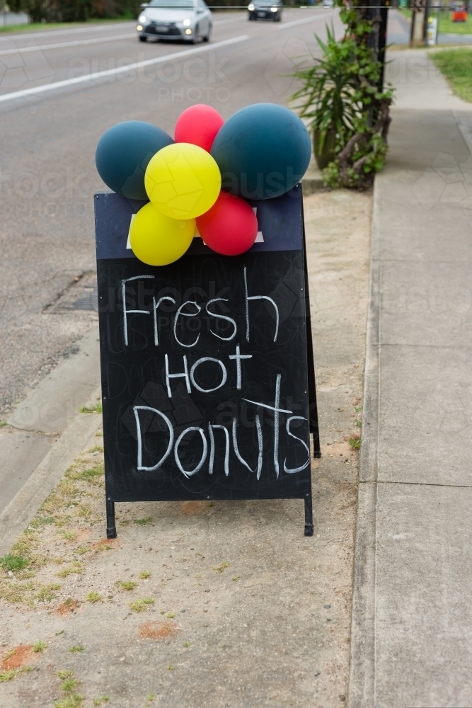 cafe sign reading Fresh Hot Donuts, with balloons - Australian Stock Image