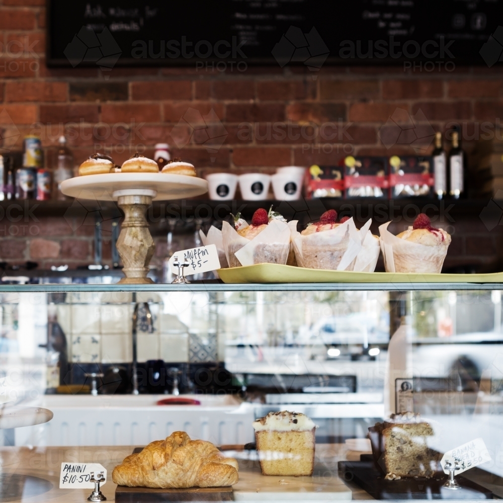 Cake display case in cafe with rustic wall behind - Australian Stock Image