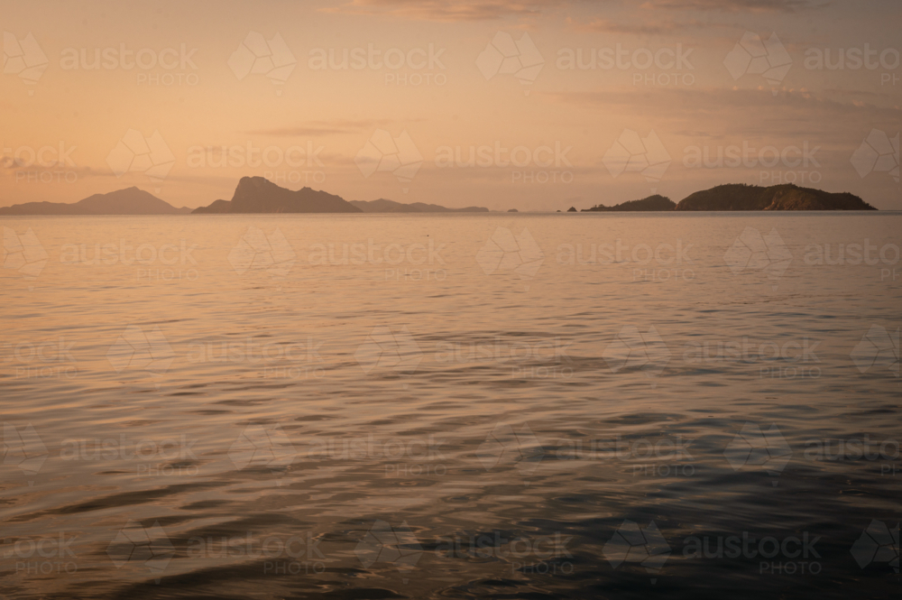 calm ocean water and hilly outcrops of islands - Australian Stock Image