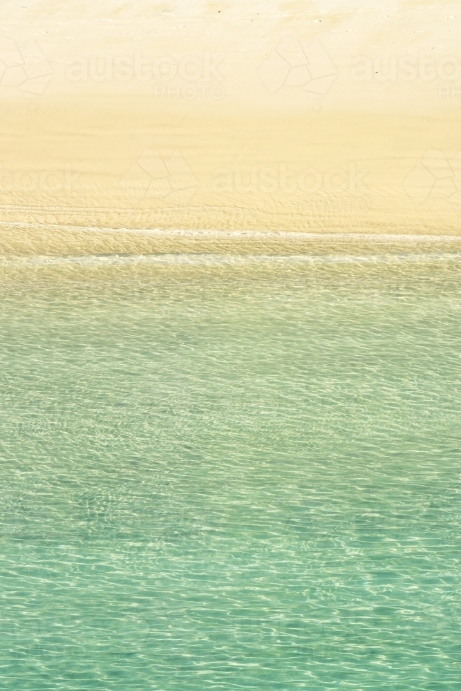 Calm seawater gentle lapping on a sandy beach - Australian Stock Image