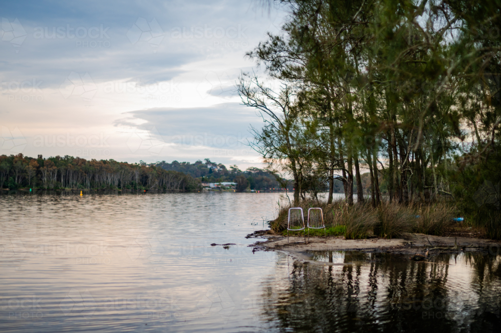 calm waters of a lake during sunset, surrounded by nature. - Australian Stock Image