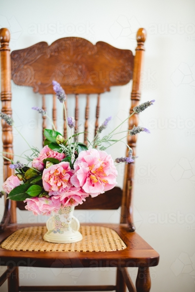 Camellias in a vase on a chair - Australian Stock Image