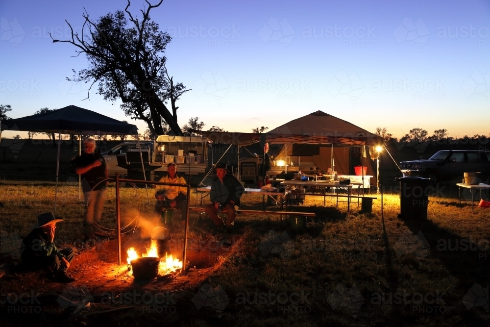 Campers gathered around a campfire - Australian Stock Image