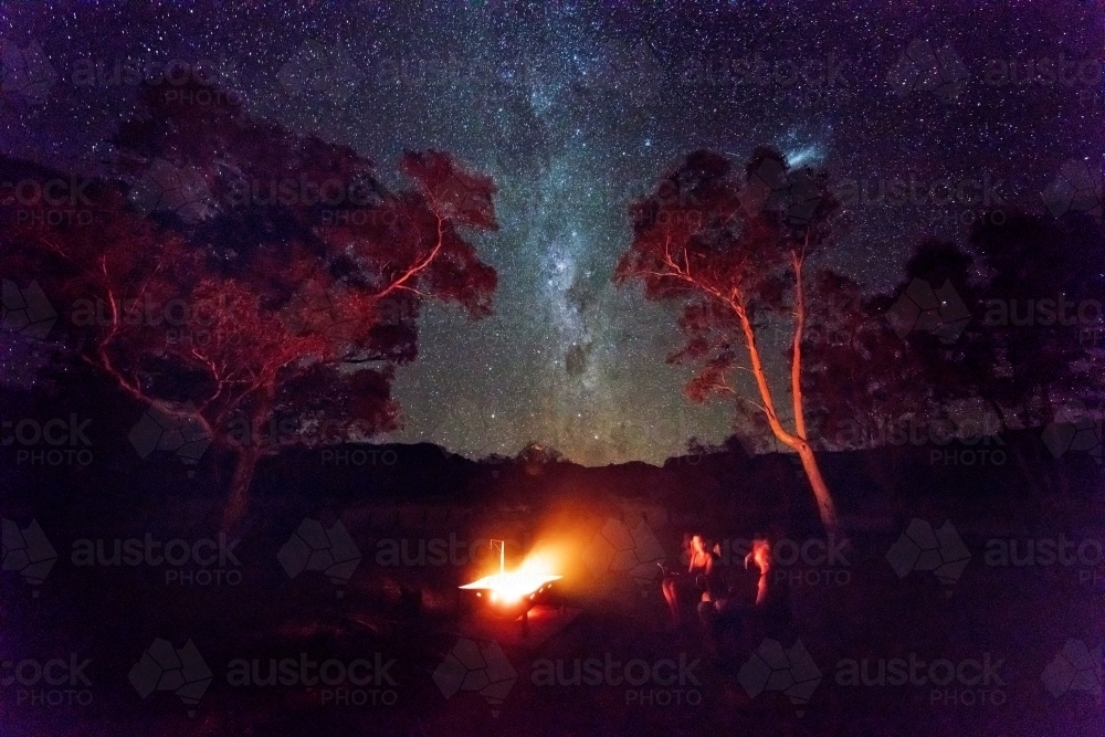 Camping and watching the campfire under stars - Australian Stock Image