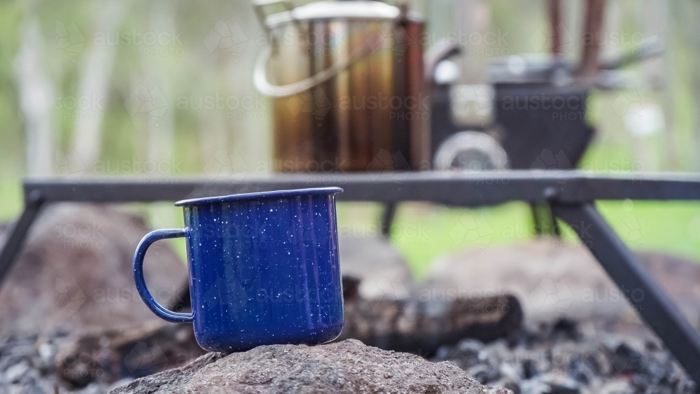 Camping coffee cup sitting on rock - Australian Stock Image