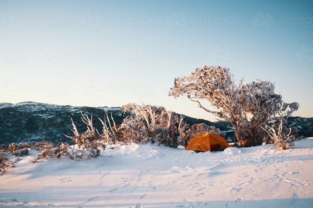 Campsite overlooking snowy landscape at dawn - Australian Stock Image