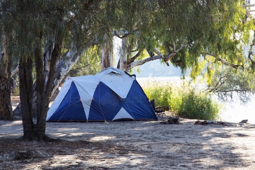 Campsite with tent by a river - Australian Stock Image