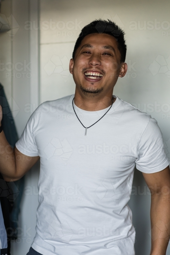 candid man getting dressed at home - Australian Stock Image