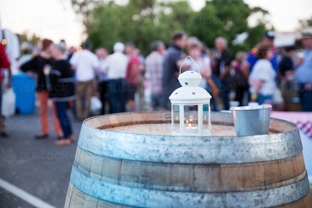 Candle on a barrel at outdoor party - Australian Stock Image