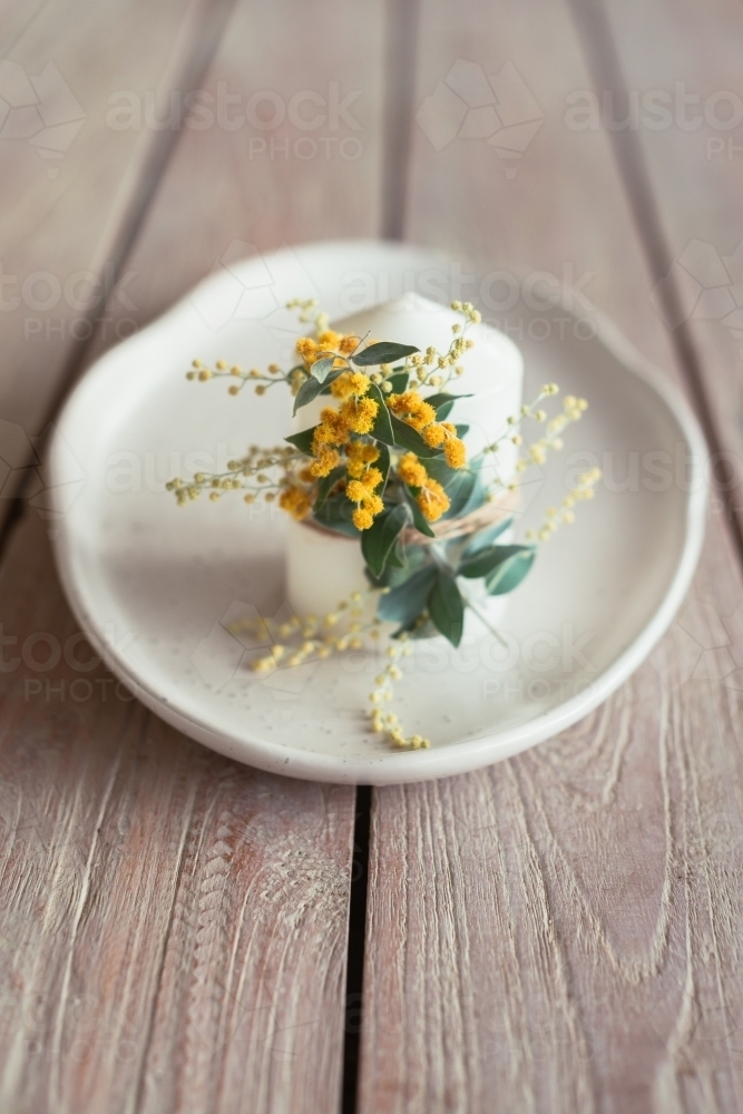 candle with wattle flower - Australian Stock Image