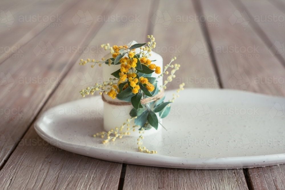 candle with wattle flower - Australian Stock Image