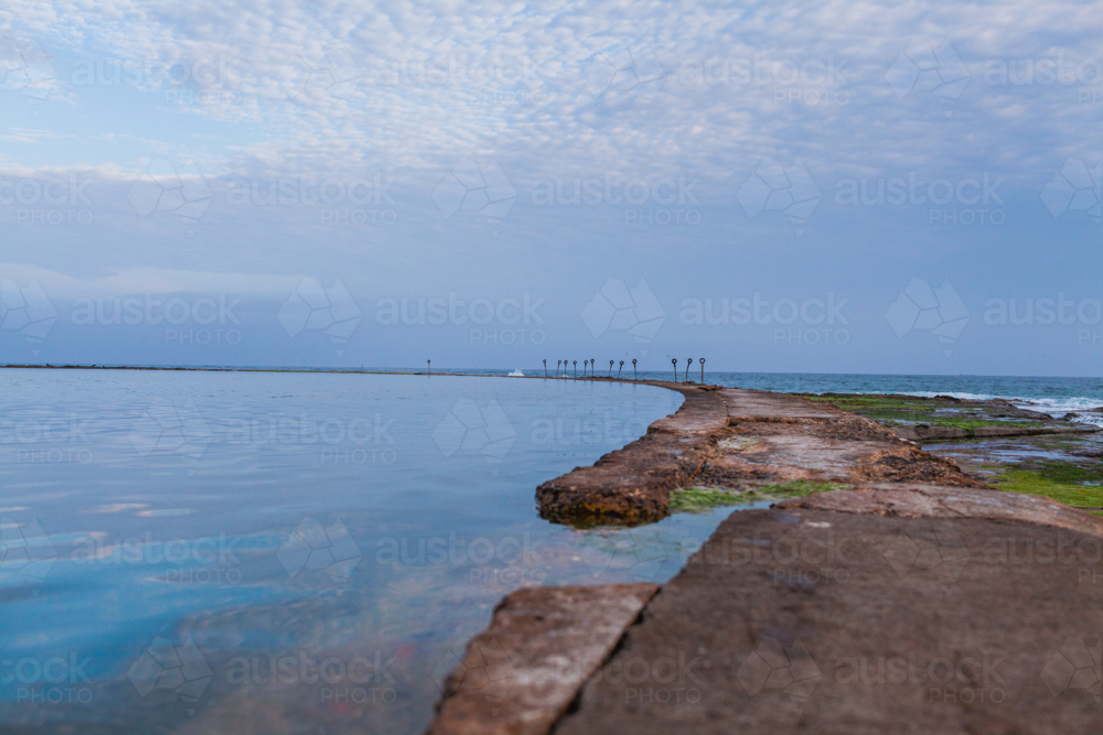 canoe pool on the coast at Newcastle Beach during overcast sunset with soft blue light - Australian Stock Image