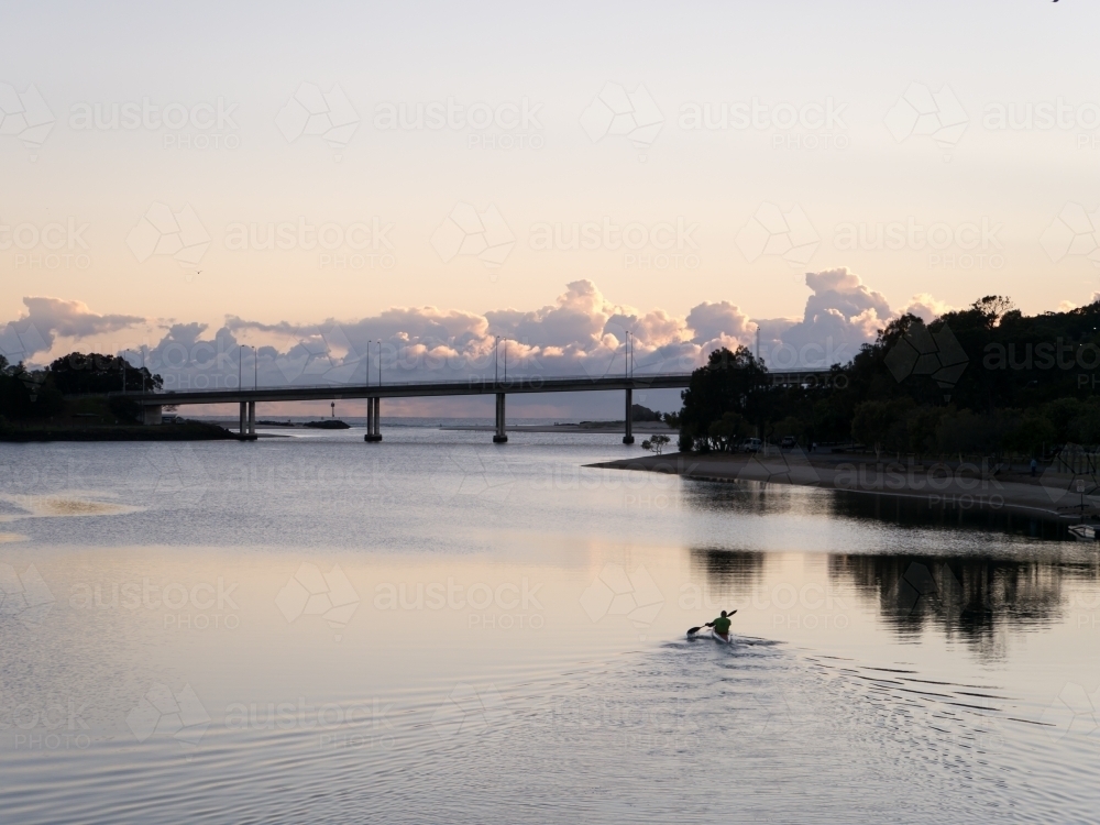 Canoeist paddling on still water in the early morning - Australian Stock Image
