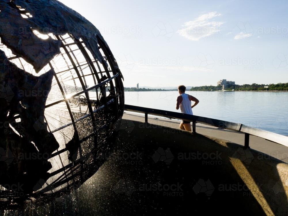 Captain Cook Memorial Globe with runner and Lake Burley Griffin - Australian Stock Image