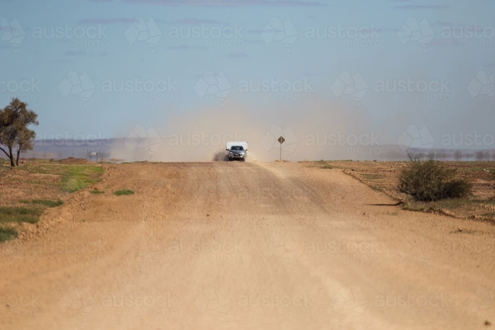 Car and caravan being driven along a wide outback road - Australian Stock Image