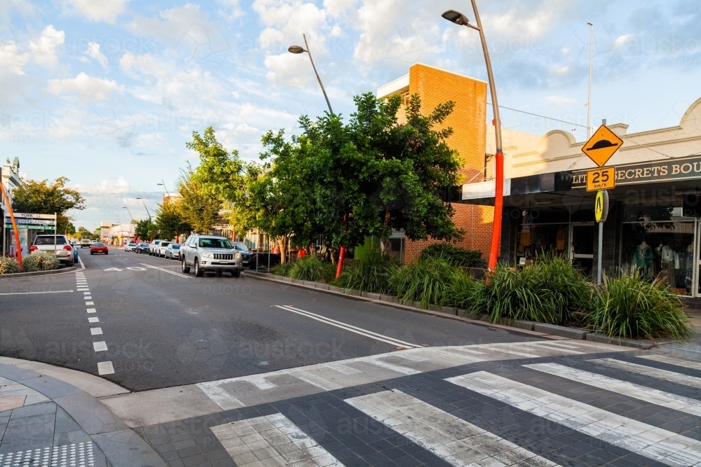 Car driving along small town road with speed hump pedestrian crossing - Australian Stock Image