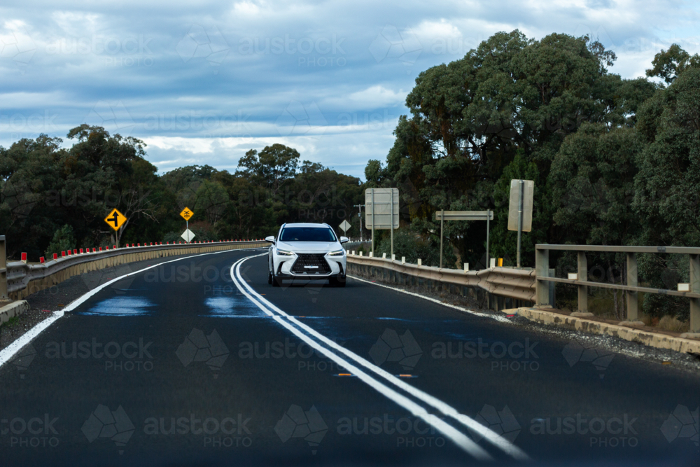 Car driving down highway over bridge - Australian Stock Image