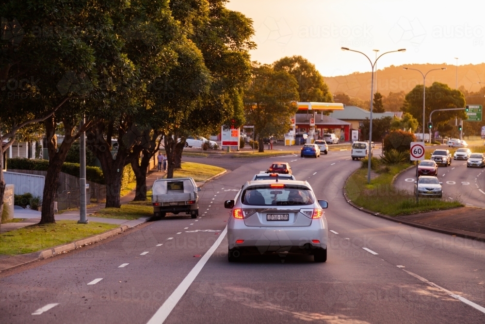 Car in heavy traffic with break lights on at sunset on multi lane road - Australian Stock Image
