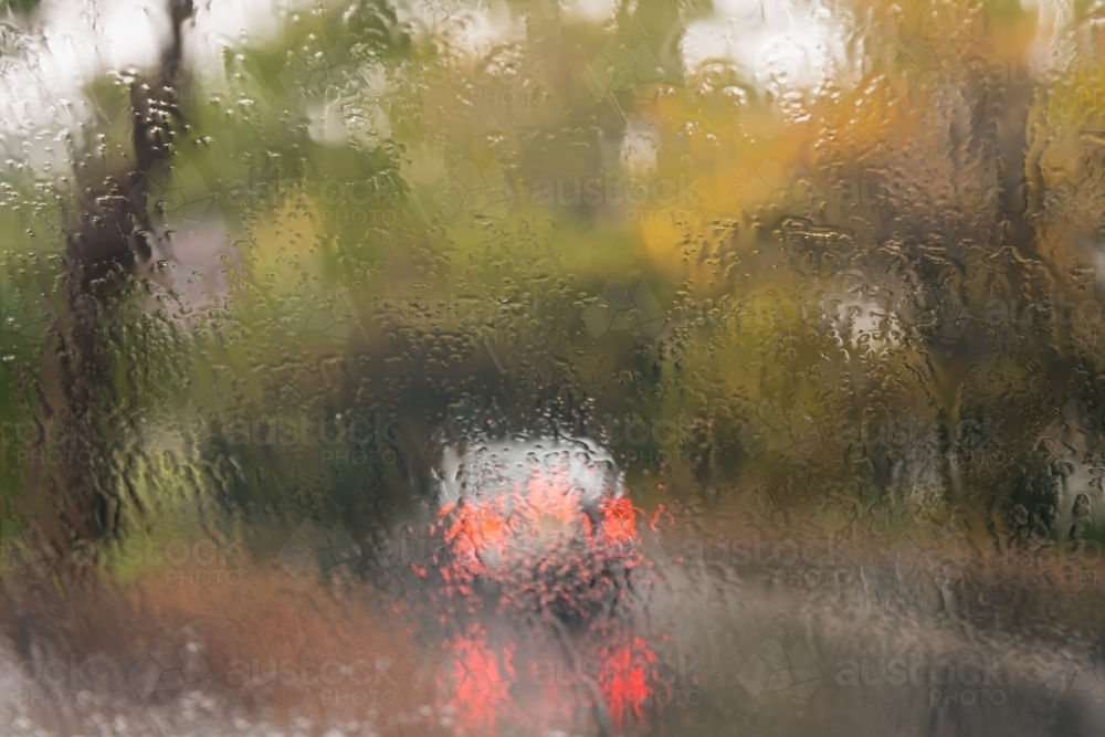 car lights seen through a wet windscreen, with autumn colours - Australian Stock Image