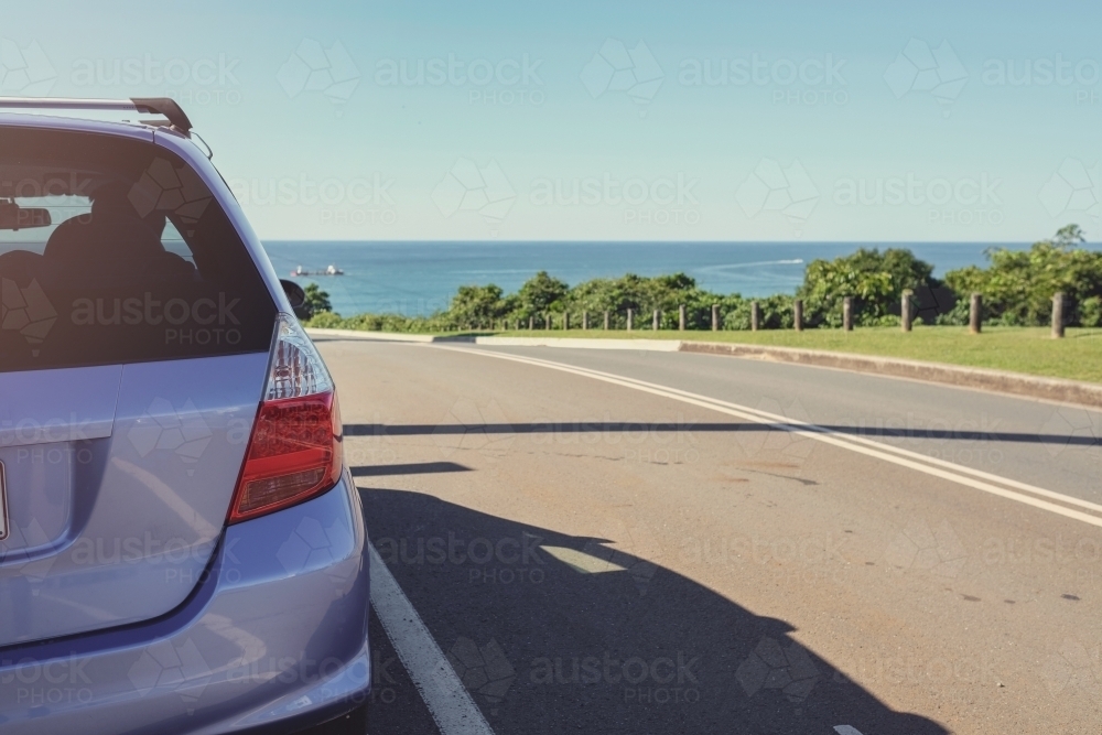 Car on roadside, ocean background - Australian Stock Image
