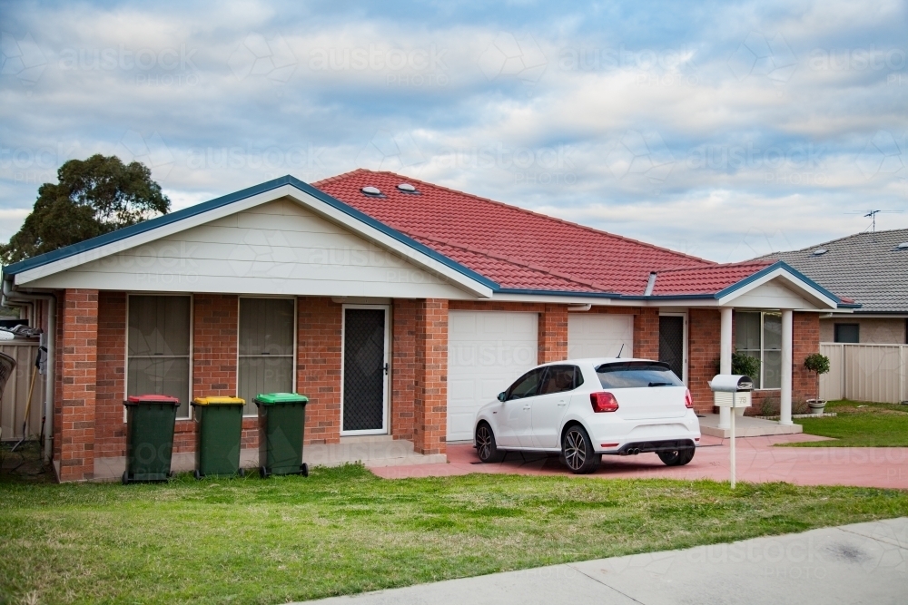 Image of Car parked in suburban residential house driveway Austockphoto