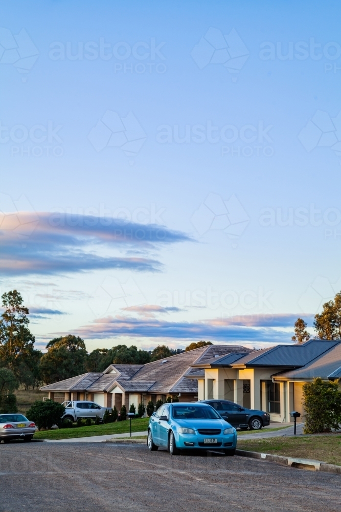 Car Parked outside of houses at dusk on the outskirts of town - Australian Stock Image
