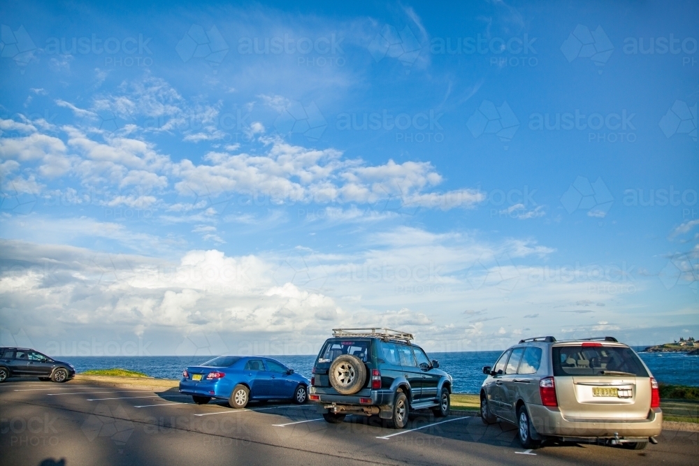Car parked over the lines in coastal car park with large sky - Australian Stock Image