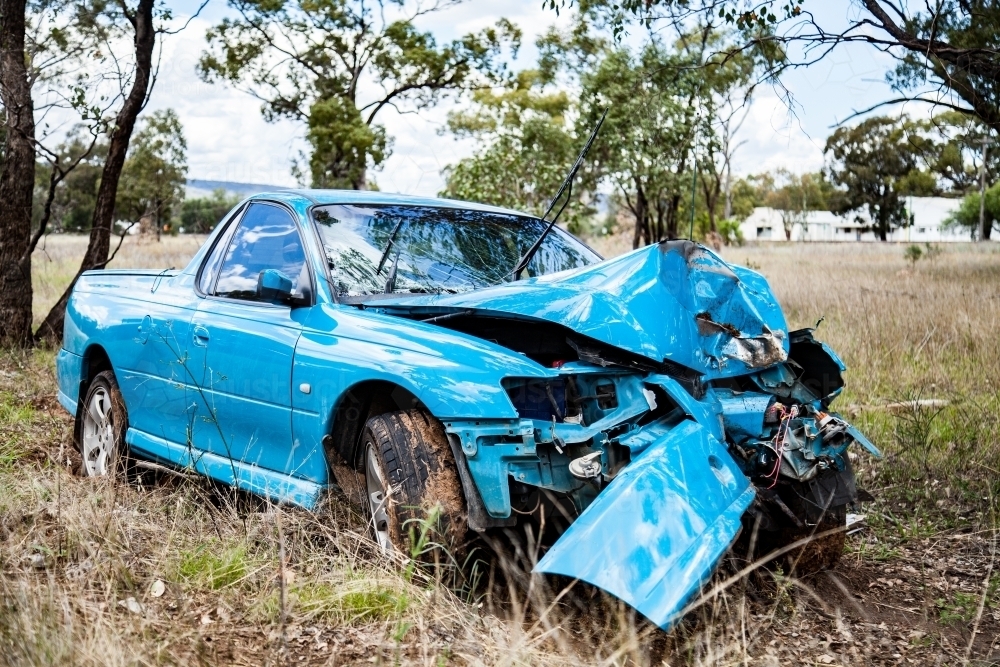 Car smashed up after running off the road and hitting a tree - Australian Stock Image