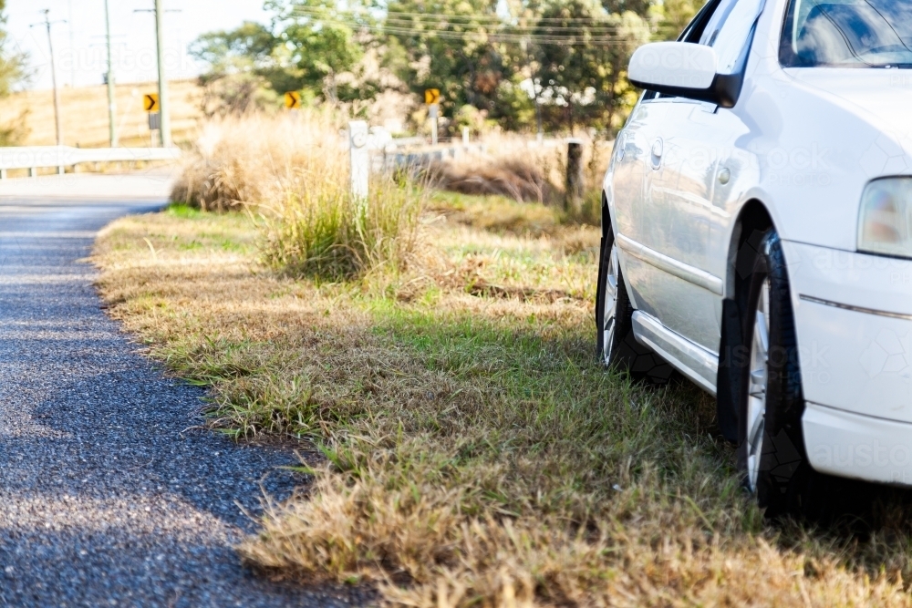 Car stopped on grass beside the road - Australian Stock Image