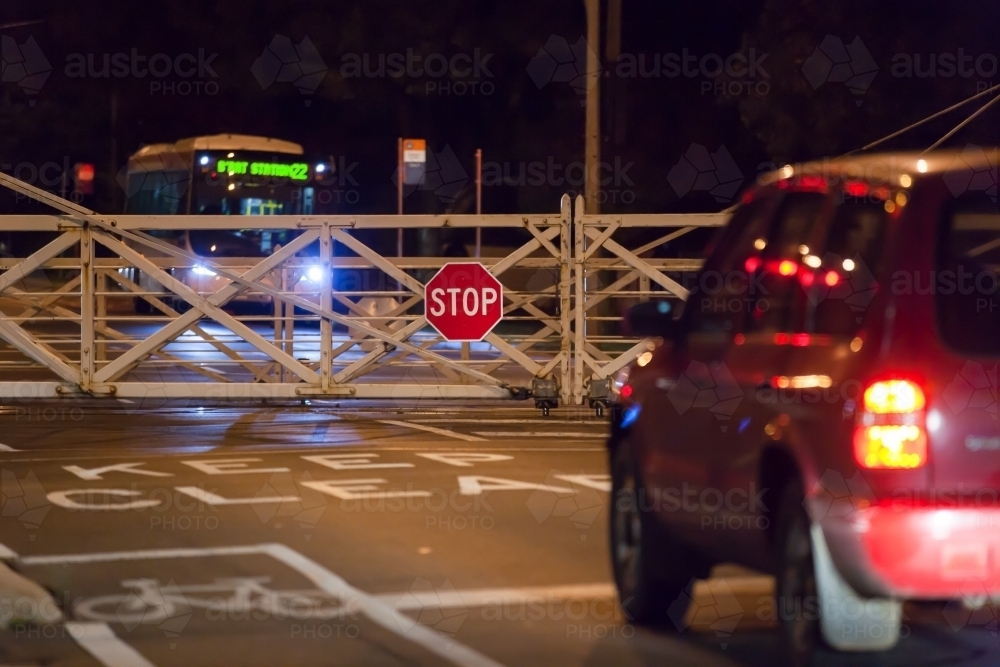 car waiting at rail crossing at night - Australian Stock Image
