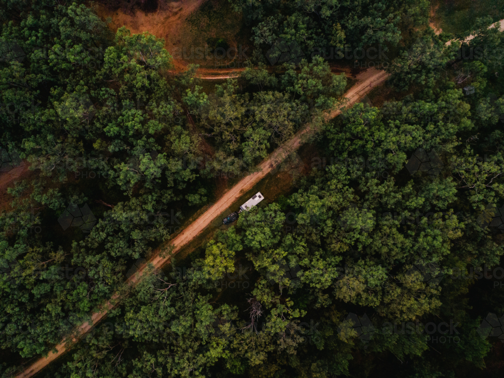 Car with caravan pulled off to the side of dirt trail in forested area in rural NSW Australia - Australian Stock Image