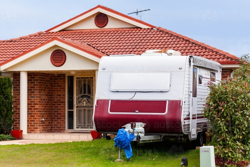 Caravan parked in front yard of home  on lawn - Australian Stock Image