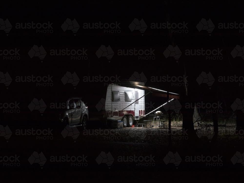 Caravan partially lit at night - Australian Stock Image