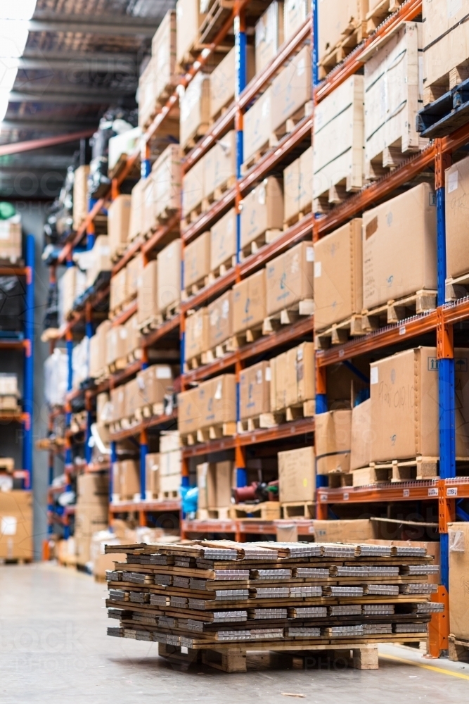 Image of Cardboard boxes on pallets in warehouse shelving Austockphoto