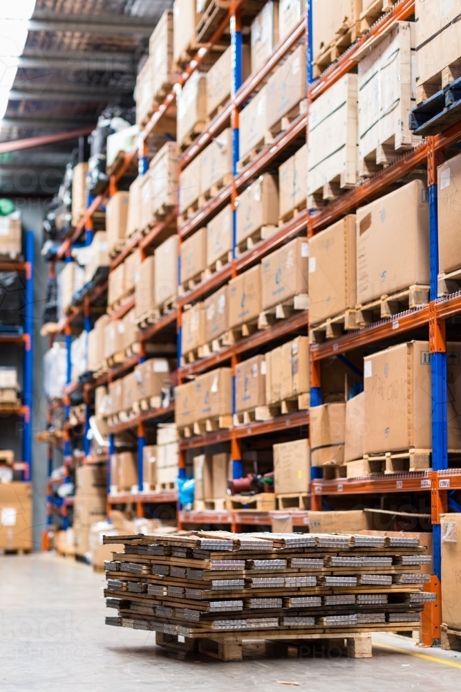 Cardboard boxes on pallets in warehouse shelving - Australian Stock Image