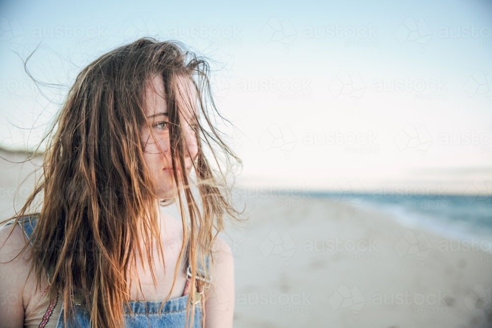 Carefree teenage girl on the beach with messy, salty hair - Australian Stock Image