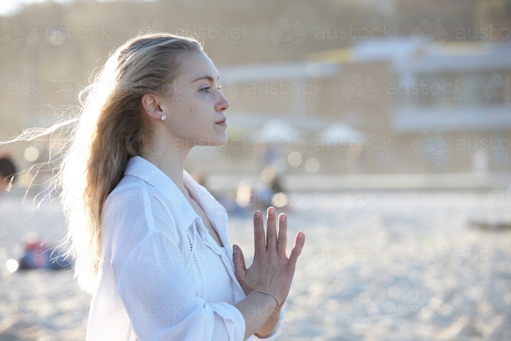 Carefree young blonde woman at beach enjoying the sunshine - Australian Stock Image
